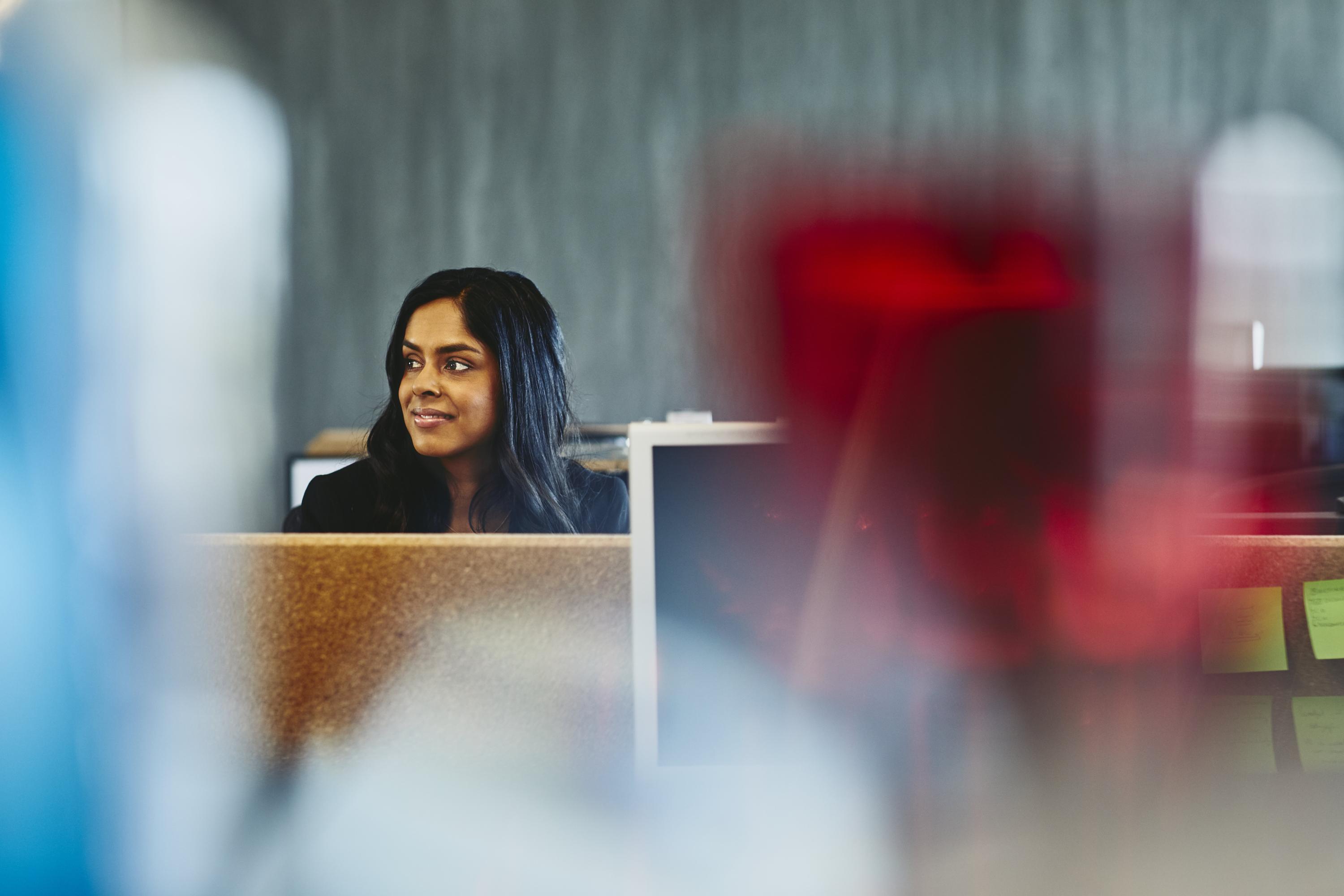 Woman at her desk. India. Primary color: red.