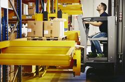 Man operating a forklift with boxes.