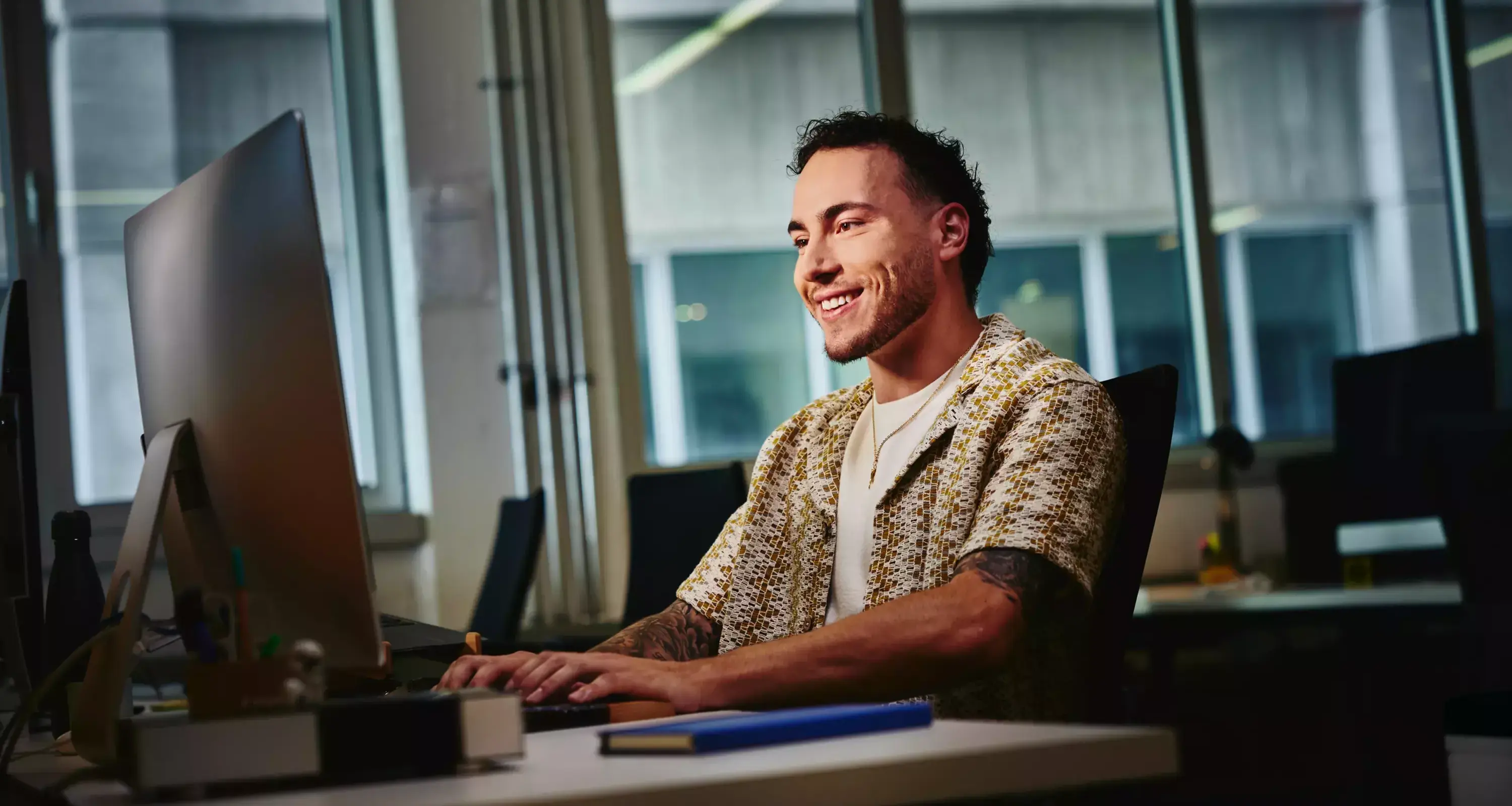 Male looking at a computer screen sitting at a desk